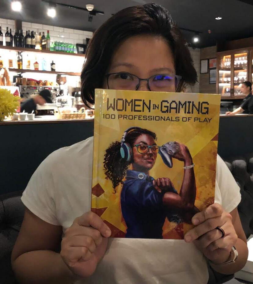 Luna Javier Luna Javier, a Filipina with short dark hair and glasses, holds up the book Women in Gaming: 100 Professionals of Play
